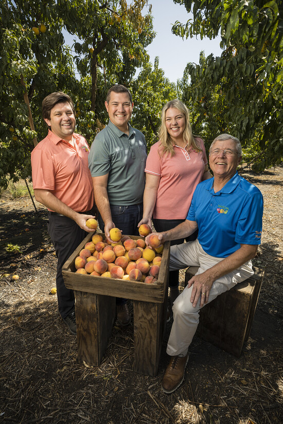 Smittcamp family proudly showcases fresh peaches in their thriving orchard for Wawona Frozen Foods.