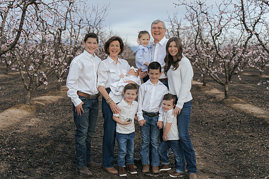 Joyful family gathering in a blooming orchard, celebrating spring and togetherness.