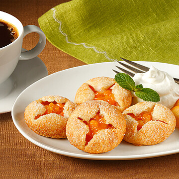 Delicious golden pastries with orange filling and coffee create a perfect brunch setting.