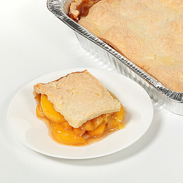 Delicious peach cobbler slice served with golden crust, showcasing homemade dessert appeal.