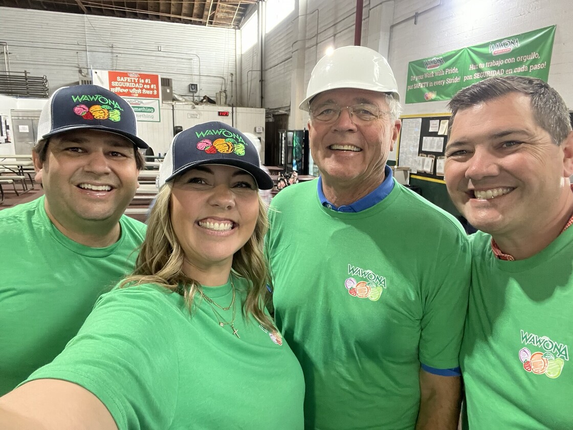 Wawona team poses in vibrant shirts, showcasing camaraderie and community spirit at Wawona Frozen Foods.